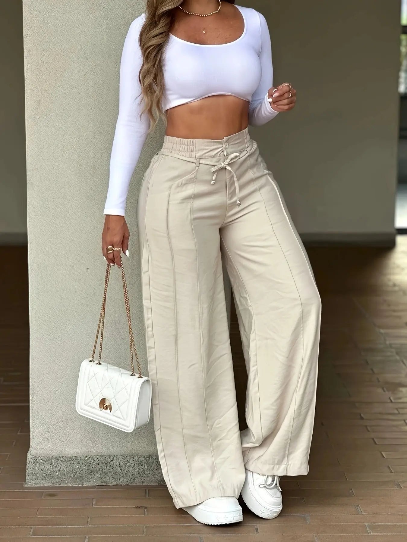 Women's casual wide-leg trousers with vertical pleats.